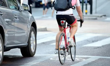 image of cyclist passing on the right of a car