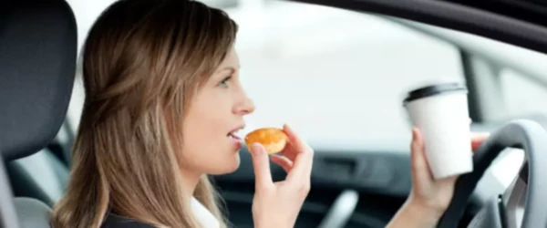 image of woman eating while driving a car