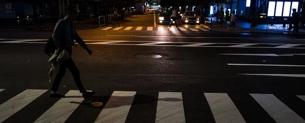 image of a pedestrian in a crosswalk at night