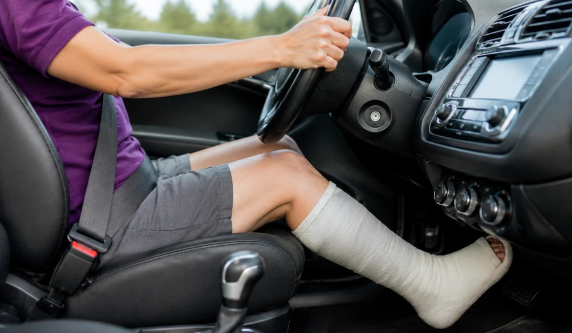 Driver with a walking cast operating a vehicle.