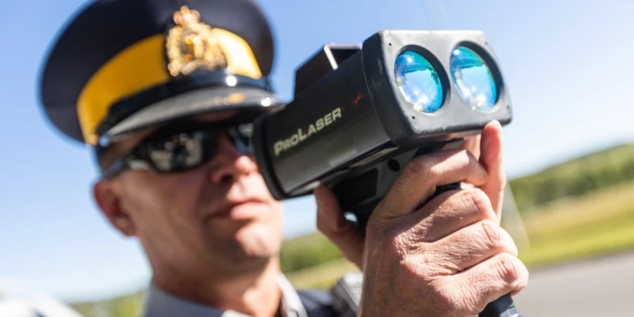 RCMP officer using a laser device to measure vehicle speed