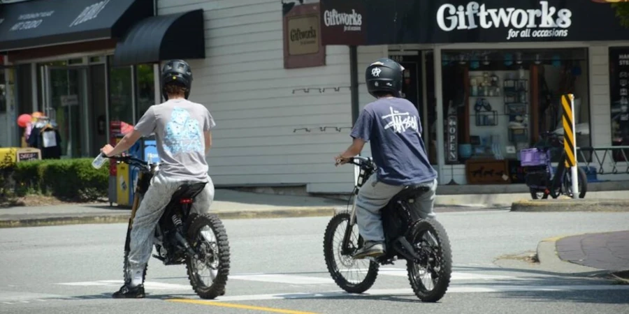 Two youth riding unlicensed dirt bikes on a public road in North Vancouver